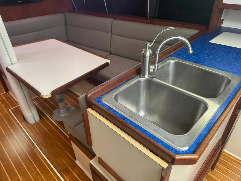 Slide: The Image of Interior of a 1989 Catalina 34 sailboat with a kitchen sink and dining area. - 11