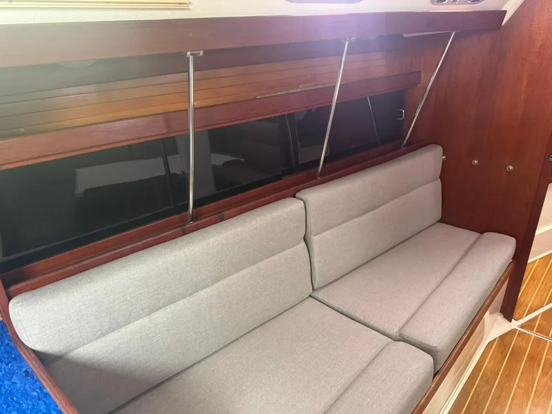 Slide: The Image of Interior of a 1989 Catalina 34 sailboat with gray cushioned seating and wooden accents. - 19