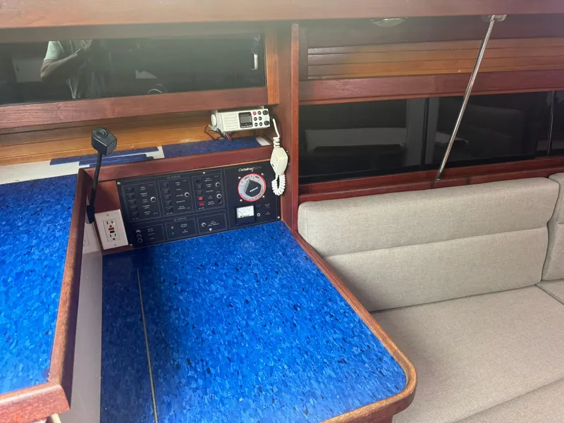 Slide: The Image of Interior of a 1989 Catalina 34 sailboat with blue navigation station and beige seating. - 20