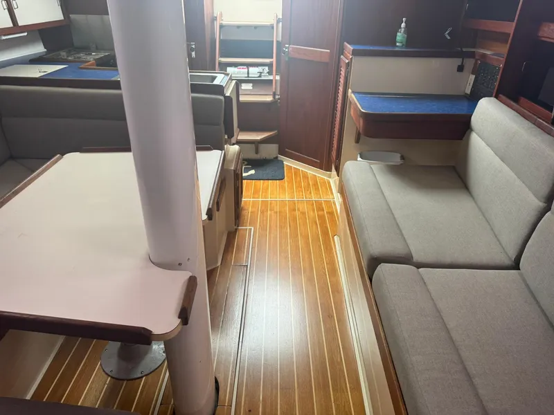 Slide: The Image of Interior of a 1989 Catalina 34 sailboat with wooden flooring and cozy seating. - 25
