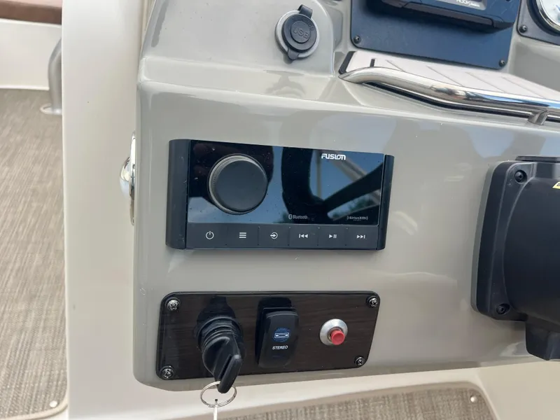 Slide: The Image of Control panel of a 2022 Stingray 212 SC boat with audio system and USB port. - 11
