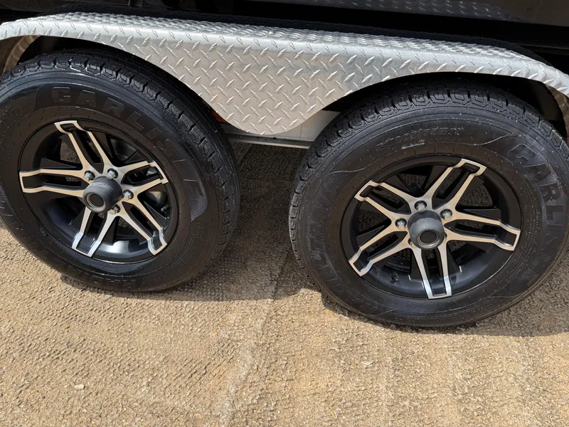 Slide: The Image of Close-up of 2022 Stingray 212 SC trailer wheels with black alloy rims. - 14