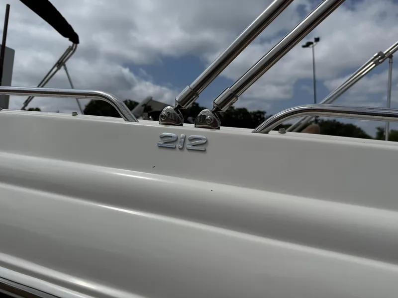 Slide: The Image of 2022 Stingray 212 SC boat detail with chrome railing under cloudy sky. - 18