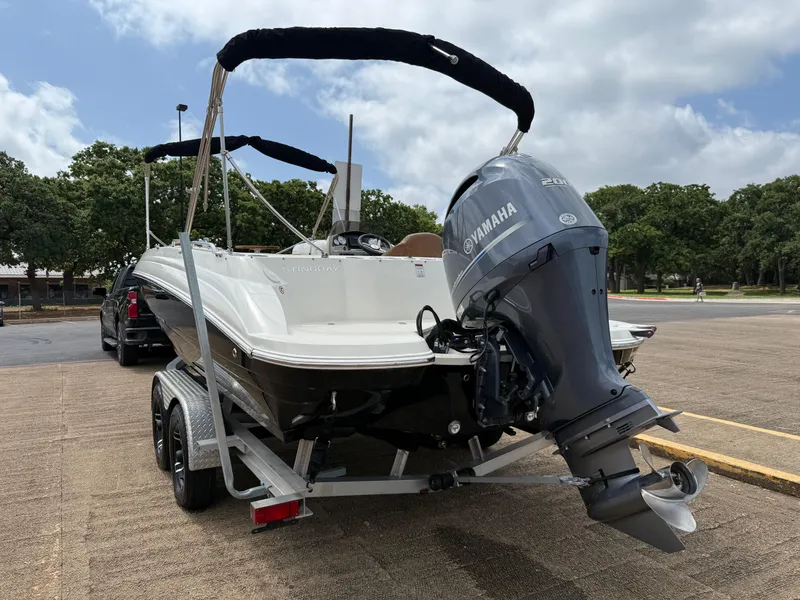 Slide: The Image of 2022 Stingray 212 SC boat with Yamaha engine on trailer, parked outdoors. - 19