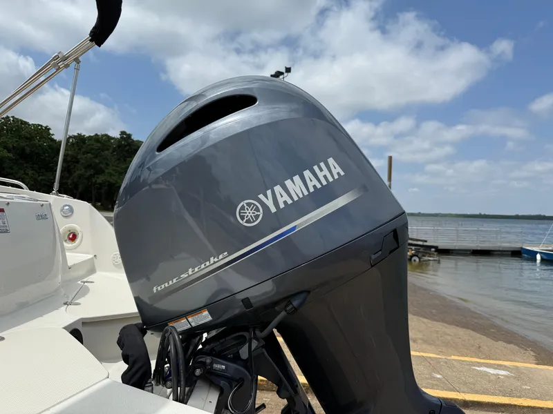 Slide: The Image of 2022 Stingray 212 SC boat with Yamaha outboard motor at a lakeside dock. - 24