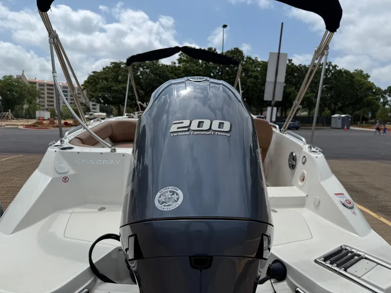Slide: The Image of 2022 Stingray 212 SC boat with 200 horsepower engine, parked outdoors. - 28