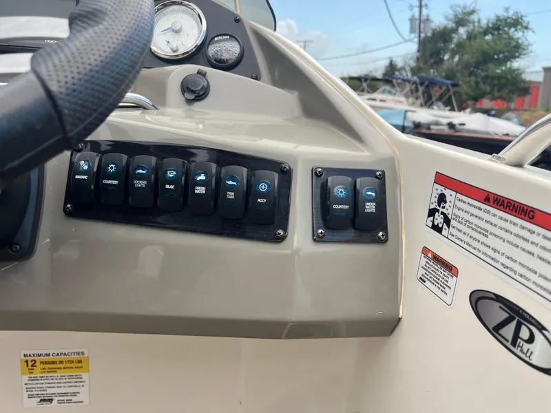 Slide: The Image of Control panel of 2022 Stingray 212 SC boat with various switches and warning labels. - 9