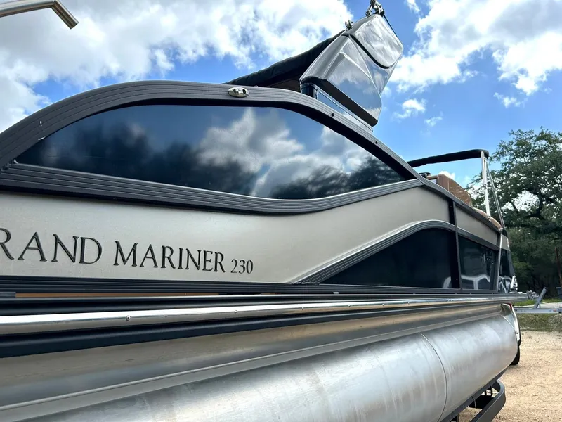 Slide: The Image of 2023 Harris Grand Mariner 230 pontoon boat under a blue sky with clouds. - 10