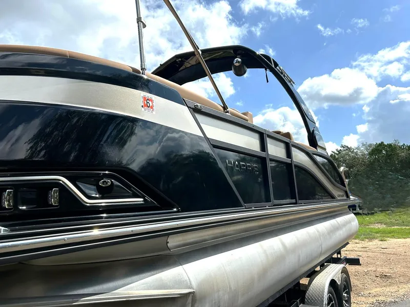 Slide: The Image of 2023 Harris Grand Mariner 230 pontoon boat under a clear blue sky. - 14