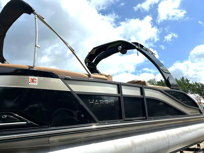 Slide: The Image of 2023 Harris Grand Mariner 230 pontoon boat under a blue sky with clouds. - 15