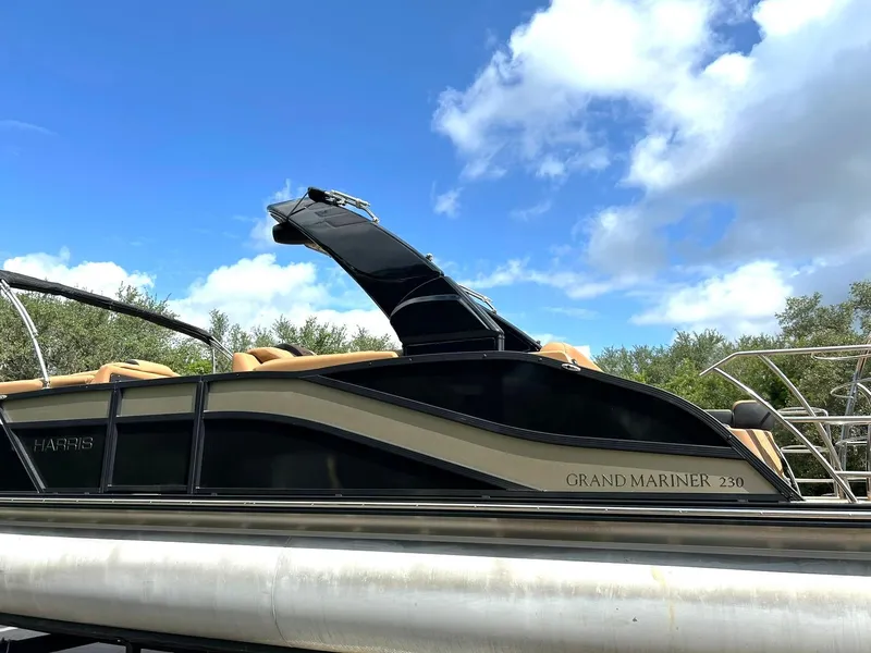 Slide: The Image of 2023 Harris Grand Mariner 230 pontoon boat under a clear blue sky. - 16