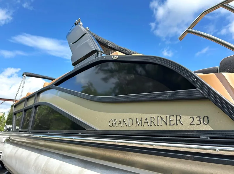 Slide: The Image of 2023 Harris Grand Mariner 230 pontoon boat under a clear blue sky. - 17