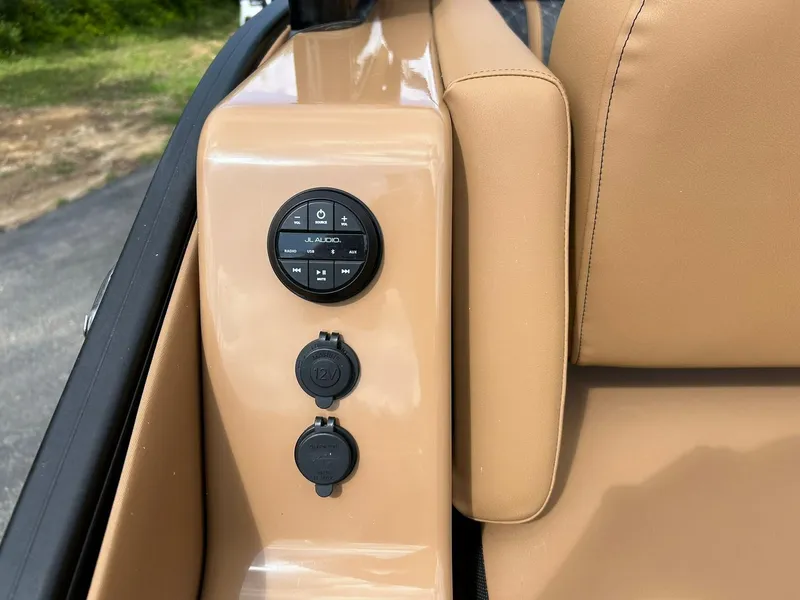 Slide: The Image of 2023 Harris Grand Mariner 230 audio controls and power outlets on tan interior panel. - 28