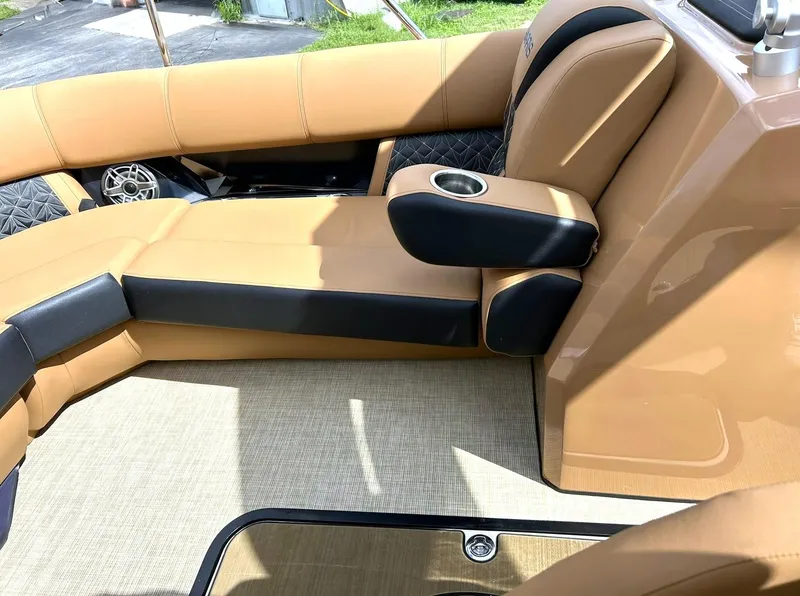 Slide: The Image of 2023 Harris Grand Mariner 230 interior with tan and black seating, cup holder, and speaker. - 47