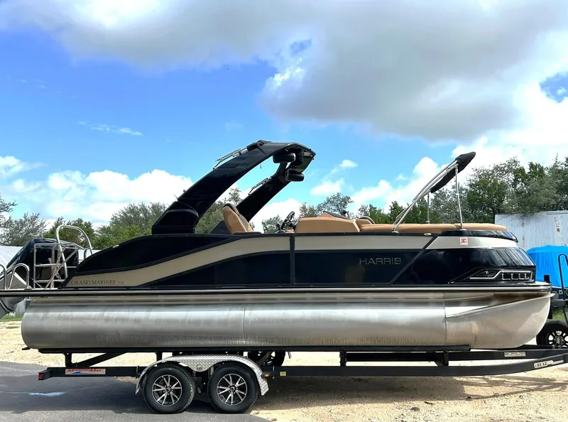 Slide: The Image of 2023 Harris Grand Mariner 230 pontoon boat on trailer under a blue sky. - 6