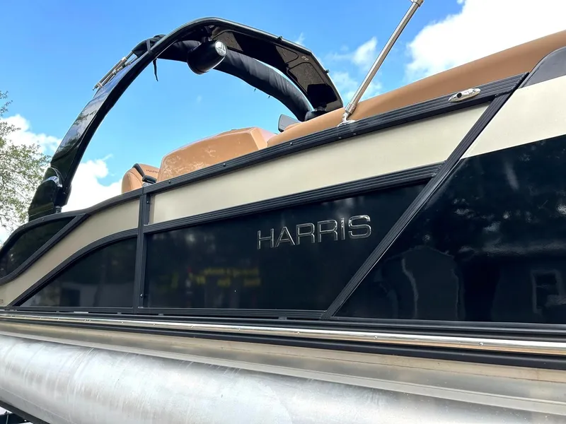 Slide: The Image of 2023 Harris Grand Mariner 230 pontoon boat with sleek black and beige design. - 9