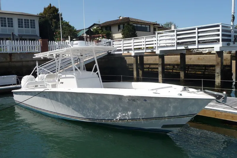 The Image of 2004 Jupiter Open Center Console boat docked near waterfront homes. - 0