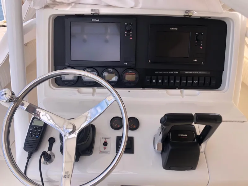 Slide: The Image of 2004 Jupiter Open Center Console boat dashboard with steering wheel and control panel. - 3