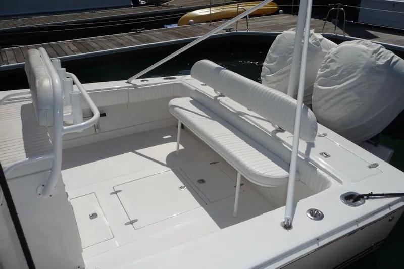 Slide: The Image of 2004 Jupiter Open Center Console boat with white seating and deck, docked at marina. - 5