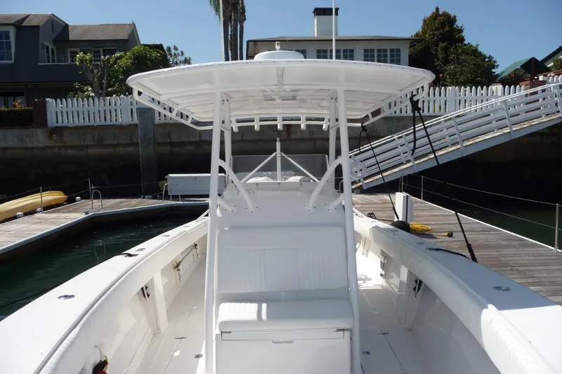 Slide: The Image of 2004 Jupiter Open Center Console boat docked at marina, showcasing spacious deck and seating. - 6