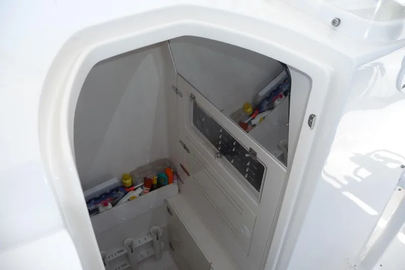 Slide: The Image of 2004 Jupiter Open Center Console boat storage compartment with various items inside. - 8