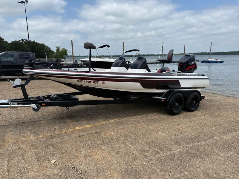 Slide: The Image of 2003 Skeeter SX190 boat on trailer by a lake, ready for launch. - 2