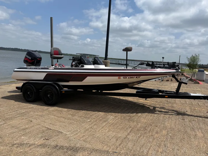 Slide: The Image of 2003 Skeeter SX190 boat parked by the lakeside. - 22