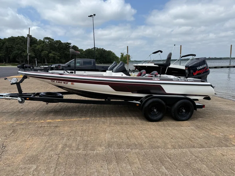 Slide: The Image of 2003 Skeeter SX190 boat on trailer by a lake, featuring Yamaha engine. - 3