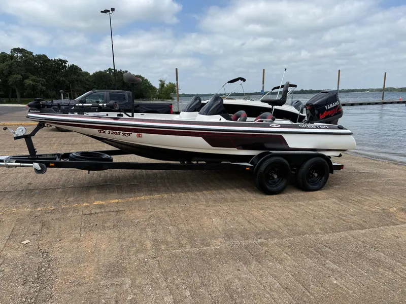 Slide: The Image of 2003 Skeeter SX190 boat on trailer by a lake, featuring Yamaha outboard motor. - 4