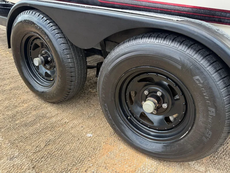 Slide: The Image of Trailer wheels of a 2003 Skeeter SX190 boat on a textured surface. - 9