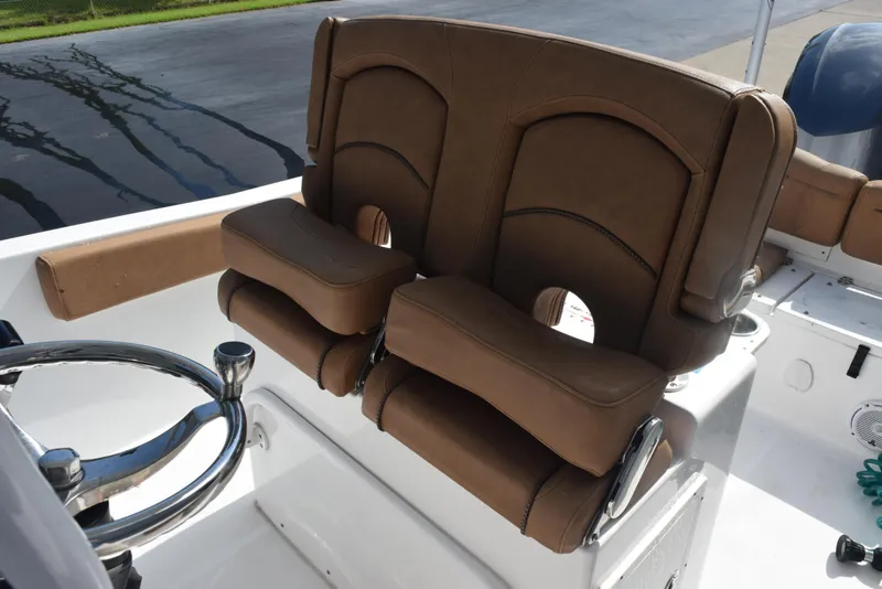 Slide: The Image of 2019 Sea Hunt Ultra 235 SE boat with brown leather seats and steering wheel. - 11