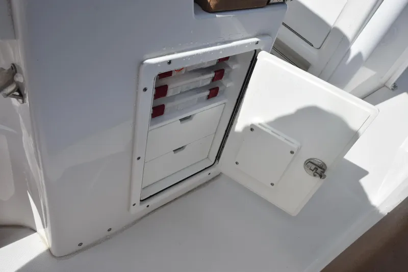 Slide: The Image of Open storage compartment on 2019 Sea Hunt Ultra 235 SE boat, featuring organized drawers. - 18