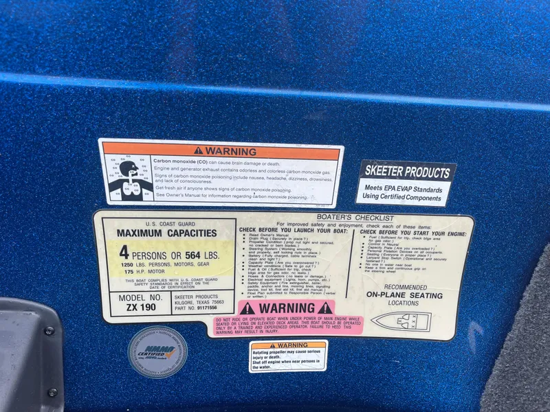 Slide: The Image of 2018 Skeeter ZX190 warning labels and capacity information on blue surface. - 24