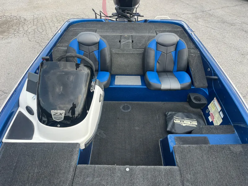 Slide: The Image of 2018 Skeeter ZX190 boat interior with blue and gray seating, steering console, and carpeted flooring. - 27