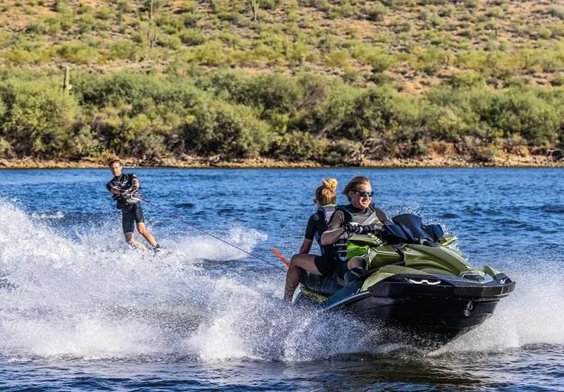 Slide: The Image of 2025 Kawasaki JetSki Ultra 160LX towing a wakeboarder on a scenic lake. - 4