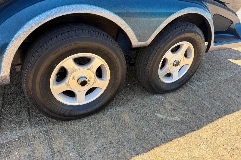 Slide: The Image of 1999 Ranger 620VS Fisherman trailer wheels on concrete surface. - 14