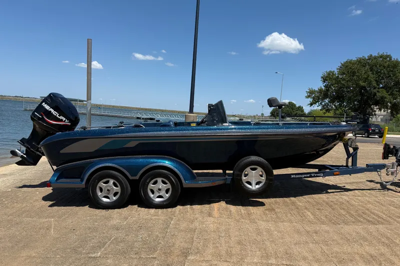 Slide: The Image of 1999 Ranger 620VS Fisherman boat on trailer by a lake under clear blue sky. - 23
