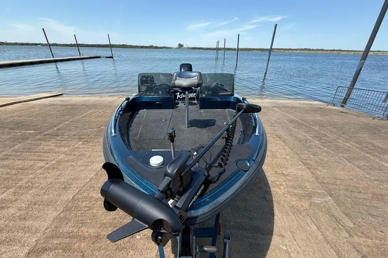 Slide: The Image of 1999 Ranger 620VS Fisherman boat at a lakeside dock under clear blue skies. - 28