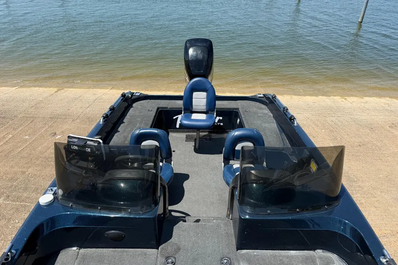 Slide: The Image of 1999 Ranger 620VS Fisherman boat with blue seats, docked by the water. - 30