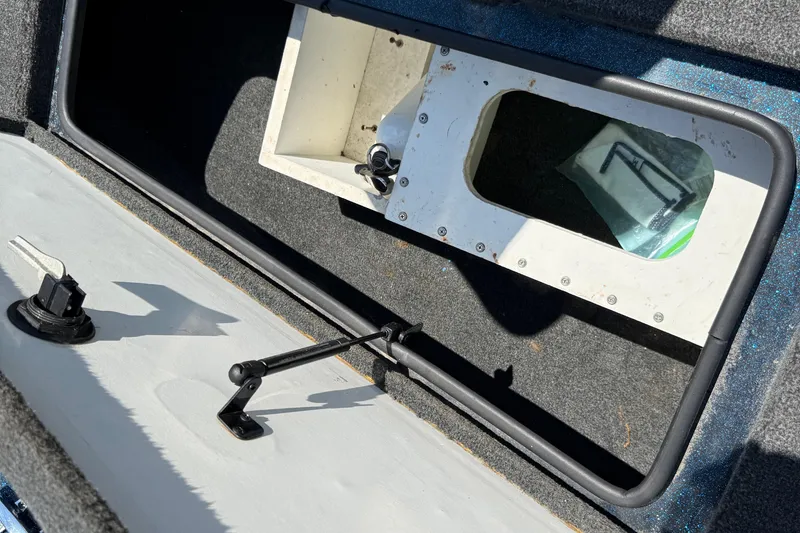 Slide: The Image of 1999 Ranger 620VS Fisherman boat storage compartment with latch and interior view. - 31
