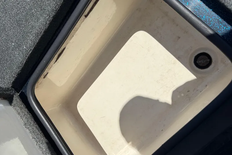 Slide: The Image of 1999 Ranger 620VS Fisherman boat compartment with drain plug, shadow visible. - 33