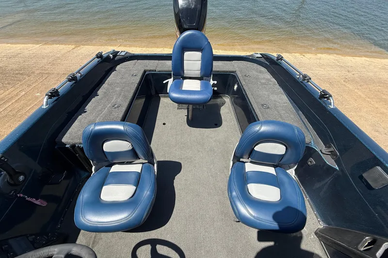 Slide: The Image of 1999 Ranger 620VS Fisherman boat interior with blue seats by the water. - 40