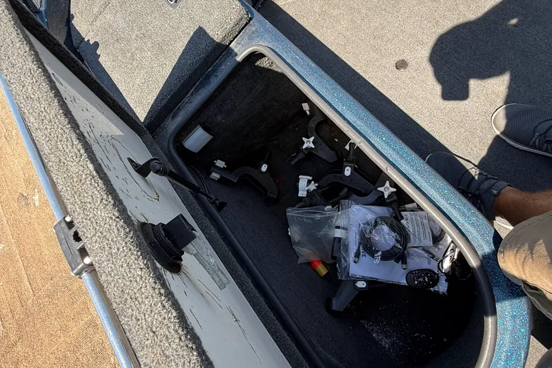 Slide: The Image of Open storage compartment in a 1999 Ranger 620VS Fisherman boat with various items inside. - 41