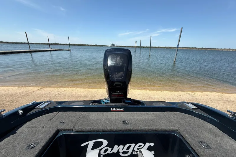 Slide: The Image of 1999 Ranger 620VS Fisherman boat at a lakeside dock, clear blue sky. - 48
