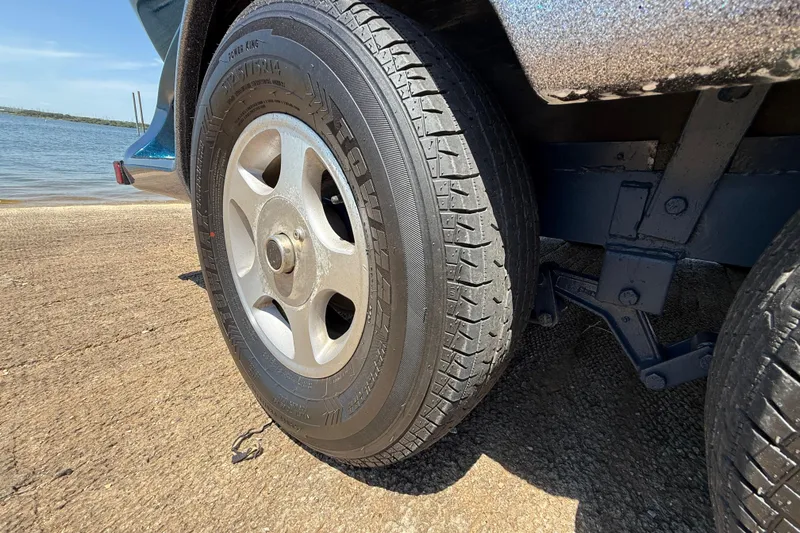 Slide: The Image of Trailer tire of a 1999 Ranger 620VS Fisherman near water. - 57