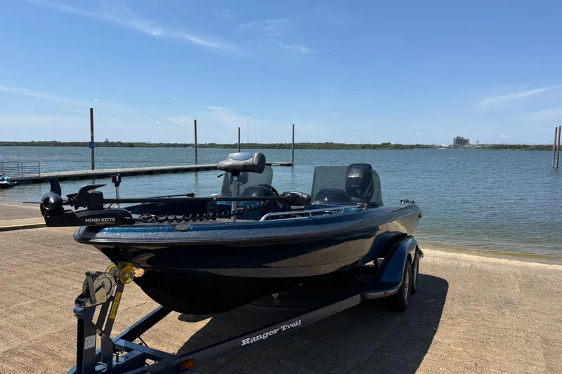 Slide: The Image of 1999 Ranger 620VS Fisherman boat on trailer by a lake under clear blue sky. - 6