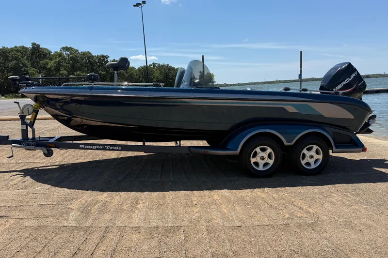 Slide: The Image of 1999 Ranger 620VS Fisherman boat on trailer by a lake. - 7