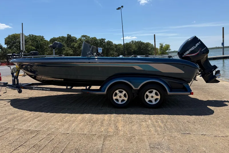 Slide: The Image of 1999 Ranger 620VS Fisherman boat on trailer by lake, featuring Mercury outboard motor. - 9