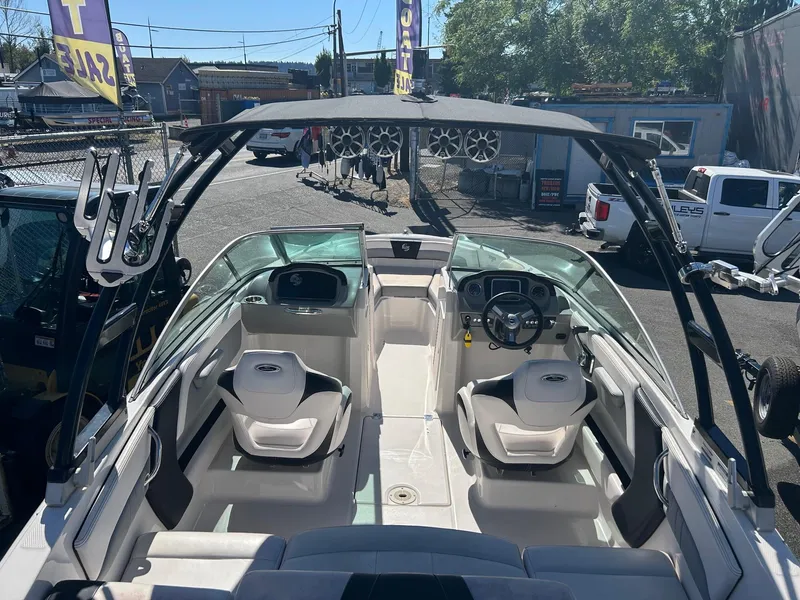 Slide: The Image of 2018 Chaparral 21 H2O Surf boat interior with seating and steering wheel, displayed outdoors. - 15