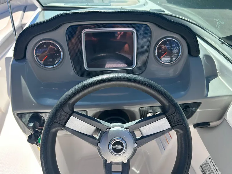 Slide: The Image of 2018 Chaparral 21 H2O Surf boat dashboard with steering wheel and gauges. - 3